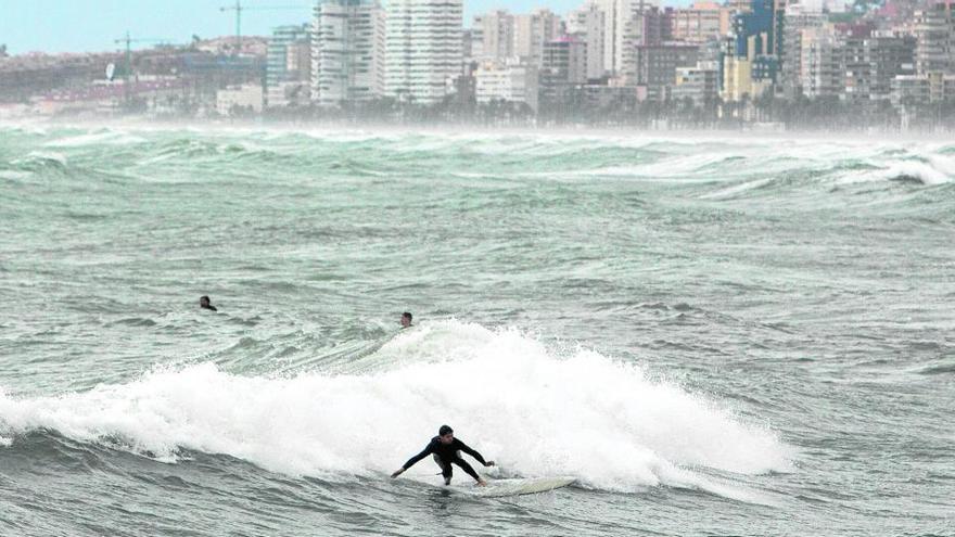 El temporal dejó olas de más de tres metros y convirtió la Playa de San Juan en un auténtico paraíso para los amantes del surf. | RAFA ARJONES