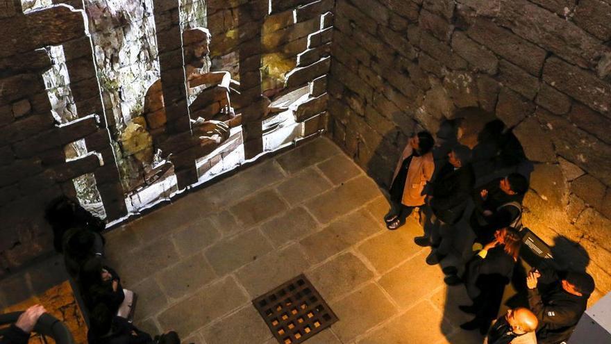 Unas personas observan una de las proyecciones en la torre del castillo de Soutomaior. / Ricardo Grobas