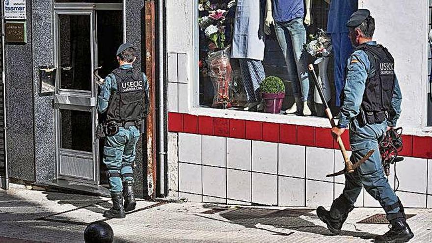 Guardias civiles, con pico y rebarbadora para el registro en el piso de Cambados.