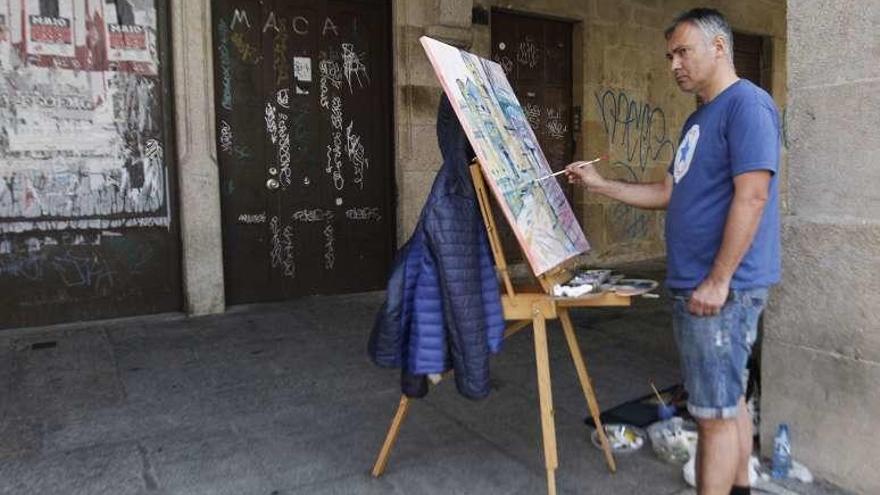 Uno de los participantes, pintando ayer en la Praza do Trigo. // J. Regal