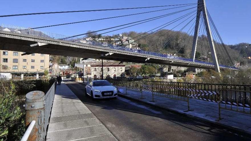 Un coche circulando por el puente viejo de Sama.