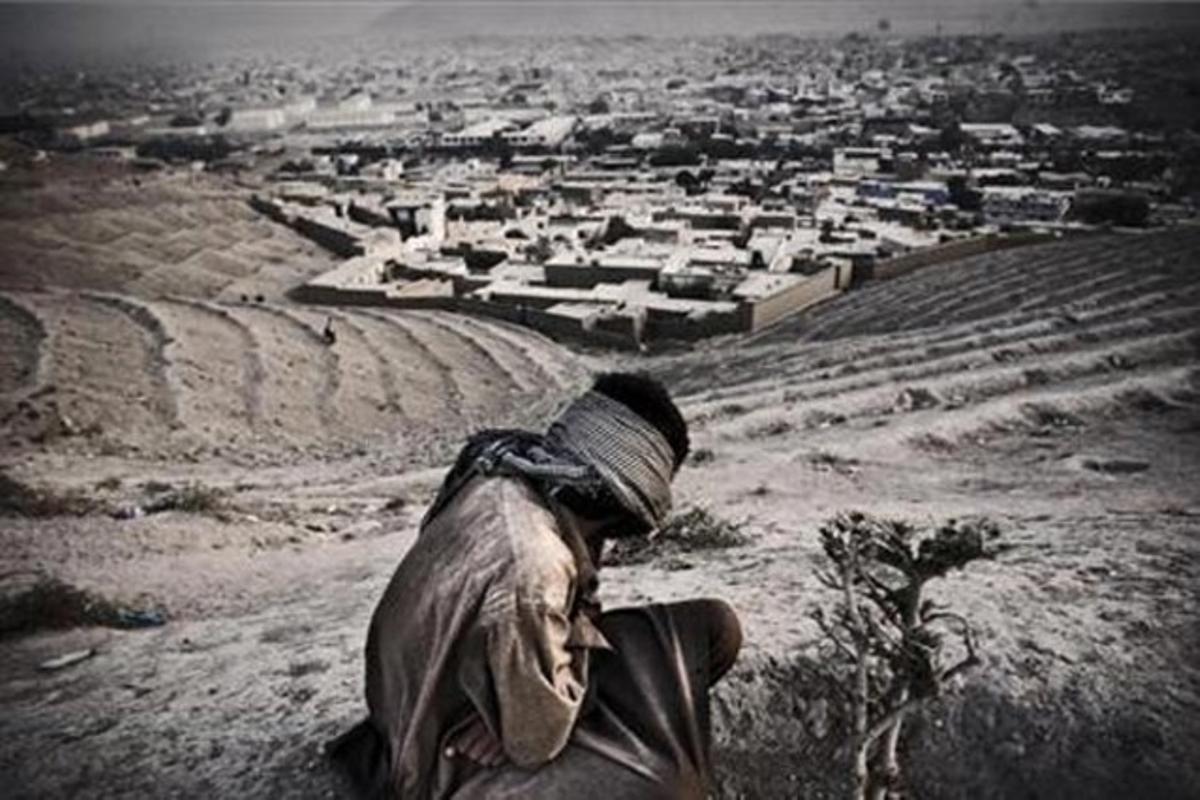 Un home contempla des de les muntanyes la ciutat on viu, a l’Afganistan.