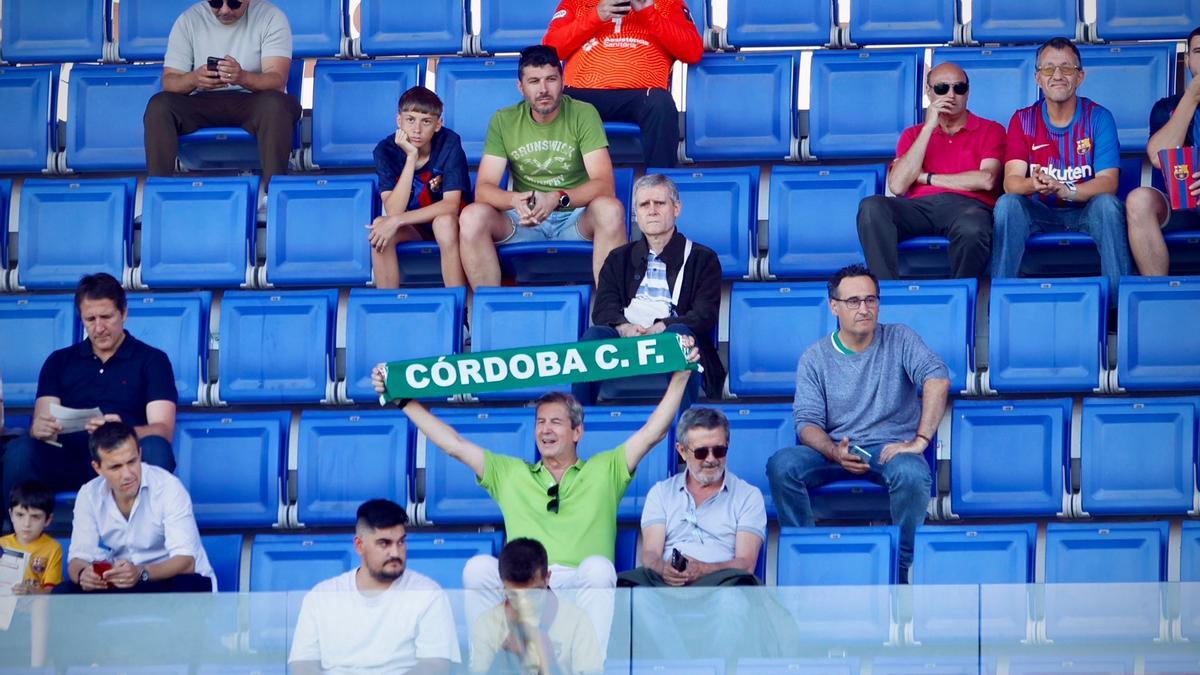 Un aficionado del Córdoba CF entre seguidores culés y asientos vacíos.