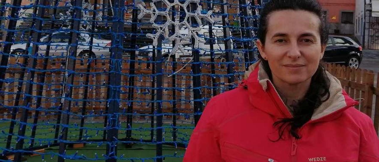 Rocío Alonso, junto al árbol de Navidad que el Ayuntamiento de Llanes ha colocado por primera vez en la plaza Parres Piñera de Posada.