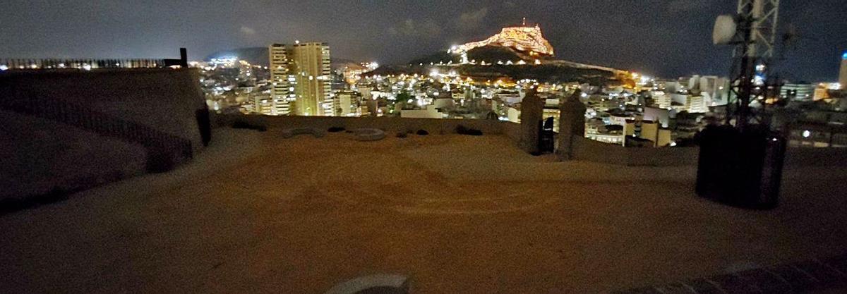 Una pareja pasea por la atalaya; a la derecha, la puerta de recepción de visitantes cerrada. | ALEX DOMÍNGUEZ