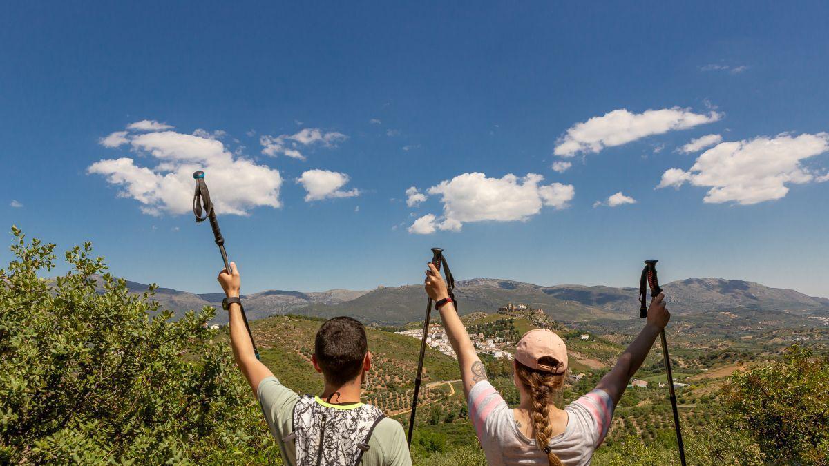 Dos senderistas observan las Sierras Subbéticas desde la ruta.