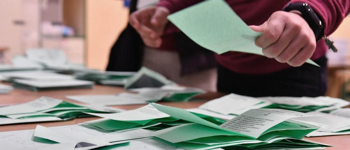 Un joven escoge papeleta en un colegio electoral.