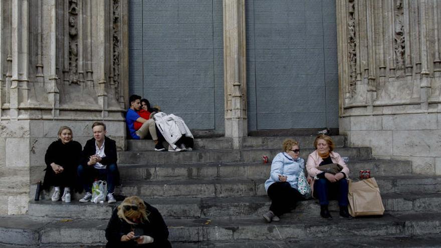 Transeúntes y turistas, ayer descansando en los escalones de la Lonja.