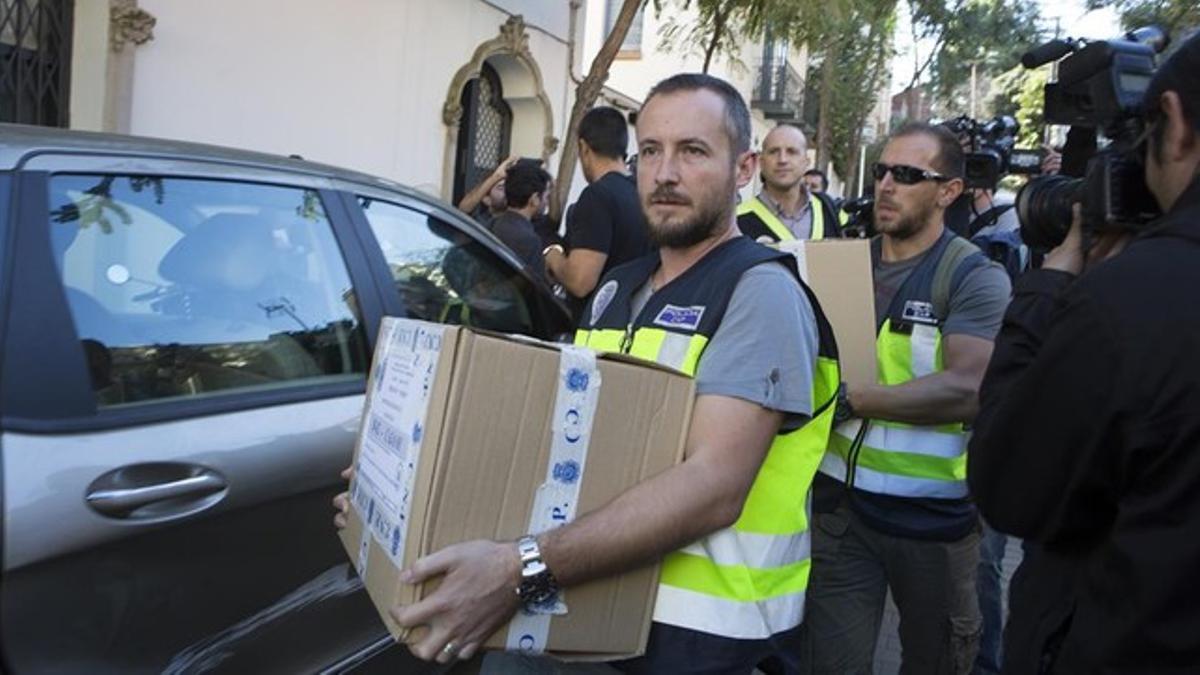 Un agente se lleva una caja con documentación del domicilio particular de Oleguer Pujol.