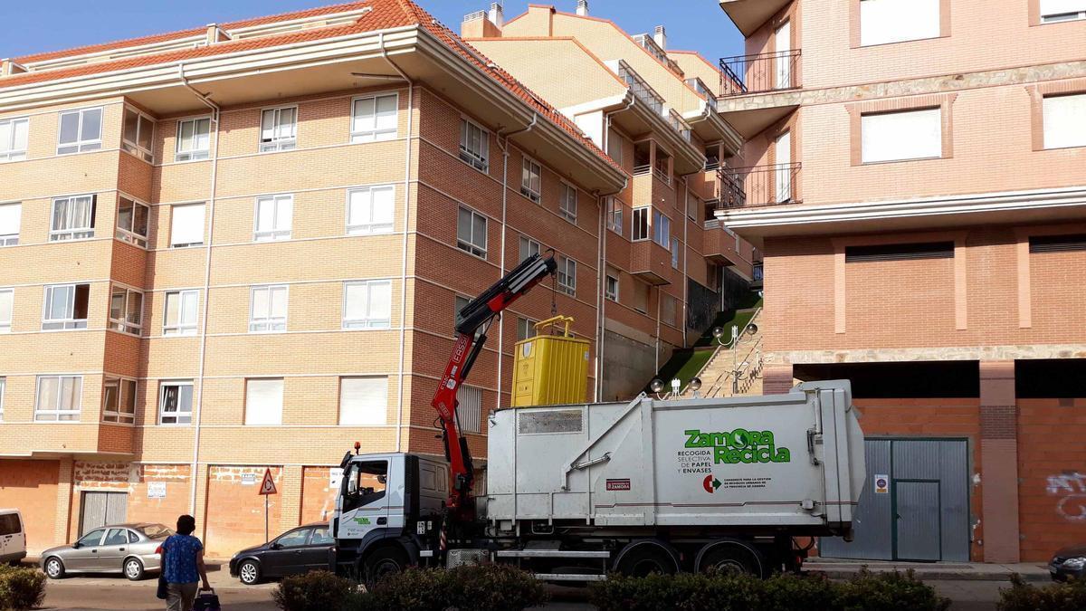 Un camión recogiendo los residuos de uno de los contenedores de la avenida Luis Morán.