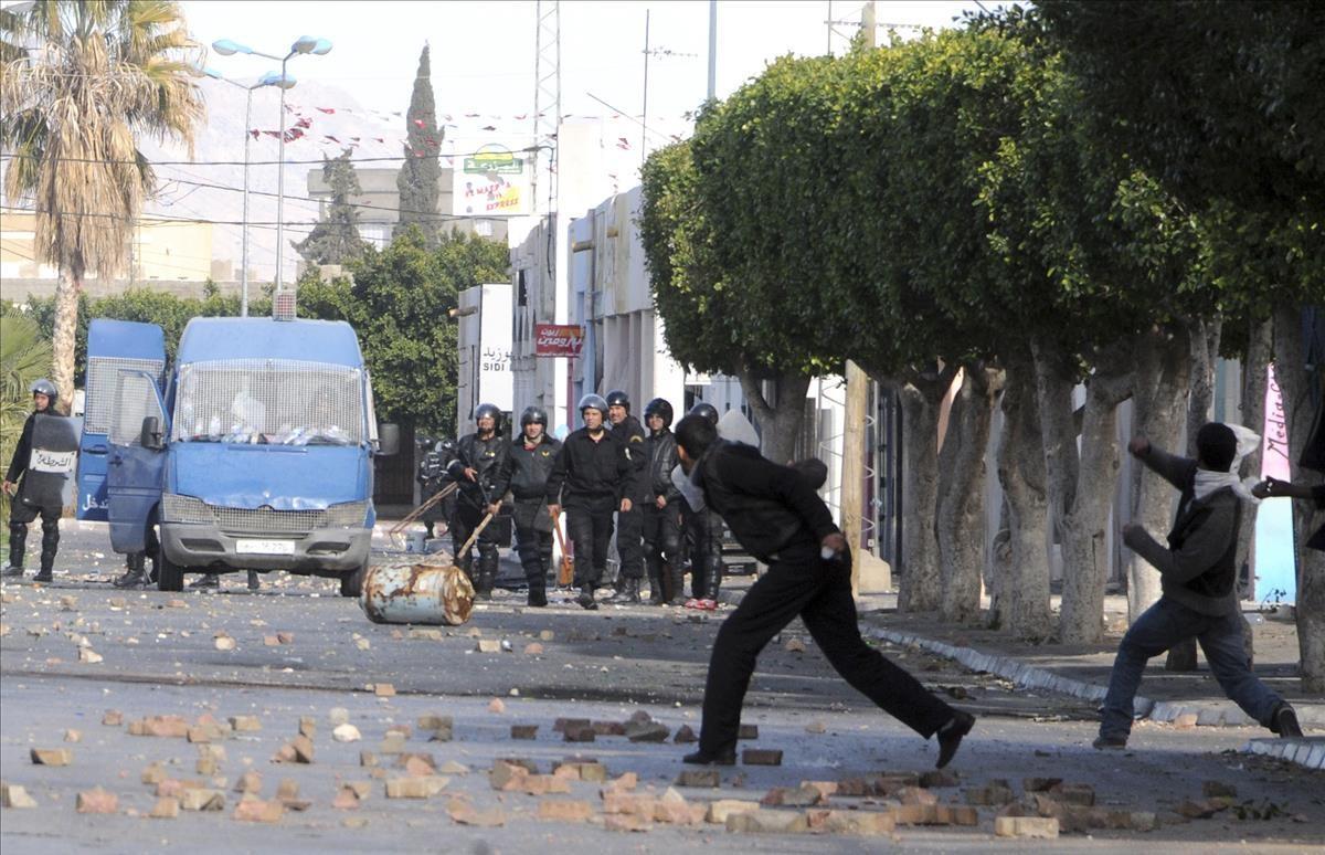 Demonstrators throw stones at police officers in Sidi Bouzid  Tunisia  Monday Jan  10  2011  Tunisia s Interior Ministry said Monday that 14 people were killed in weekend rioting in three towns in the deadliest episodes in more than three weeks of unusual unrest in this popular tourist destination  Union officials around Tunisia have provided their own death counts  higher than the official number  (AP Photo)