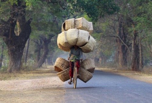 Una mujer en bicicleta lleva canastas para vender en las montañas de Lapdaung