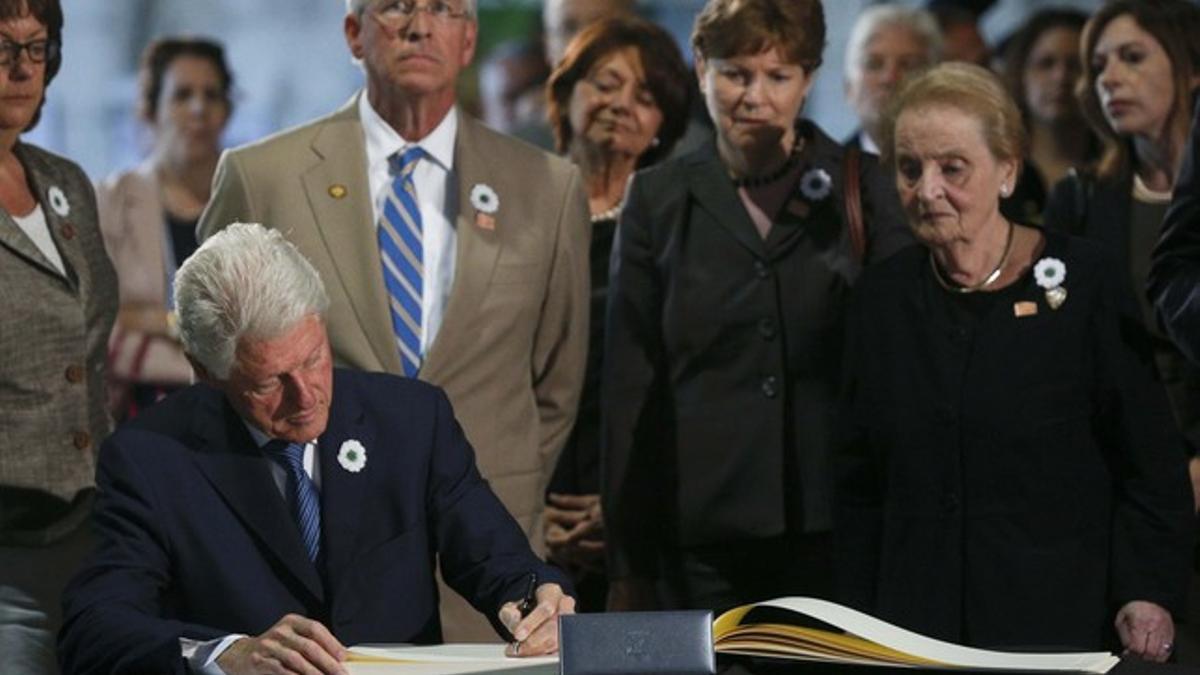 Bill Clinton, expresidente de EEUU, firma en el libro de condolencias ante la mirada de Madeleine Albright, exsecretaria de Estado de Estados Unidos.