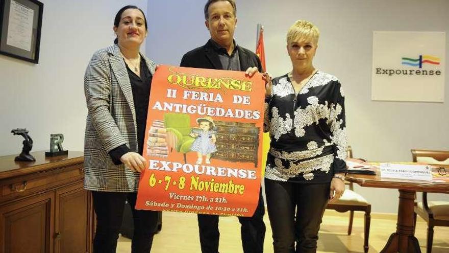 Ángel Moix, en el centro, muestra el cartel de la feria. // Brais Lorenzo