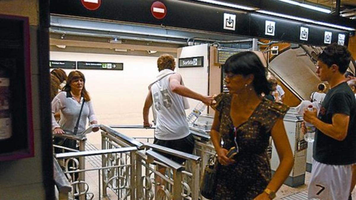 Viajar gratis 8 Unos turistas estadounidenses (arriba y abajo) y una mujer (centro) acceden al metro sin pagar en Passeig de Gràcia, ayer.