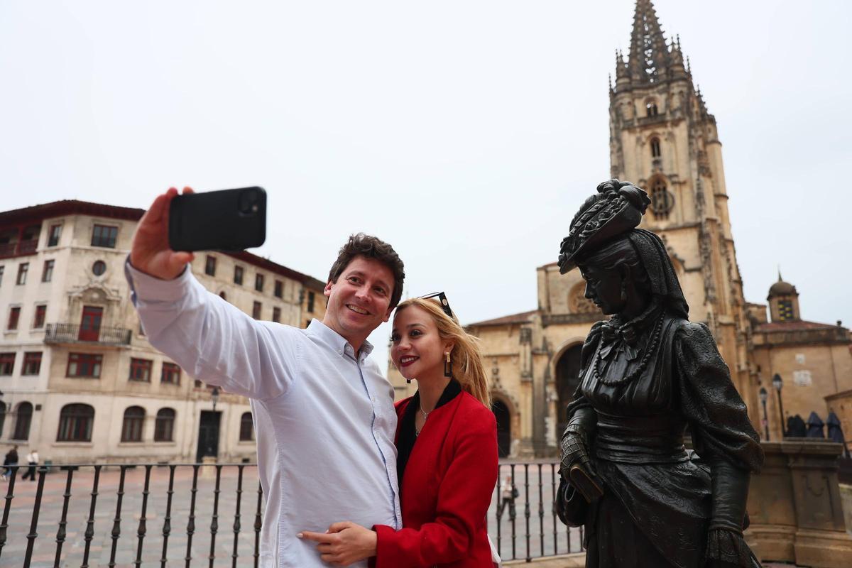 Jaime Alvarez y Camila Chacón, turistas de Madrid, en pleno selfie, en el centro de Oviedo, con la Catedral y la Regenta.