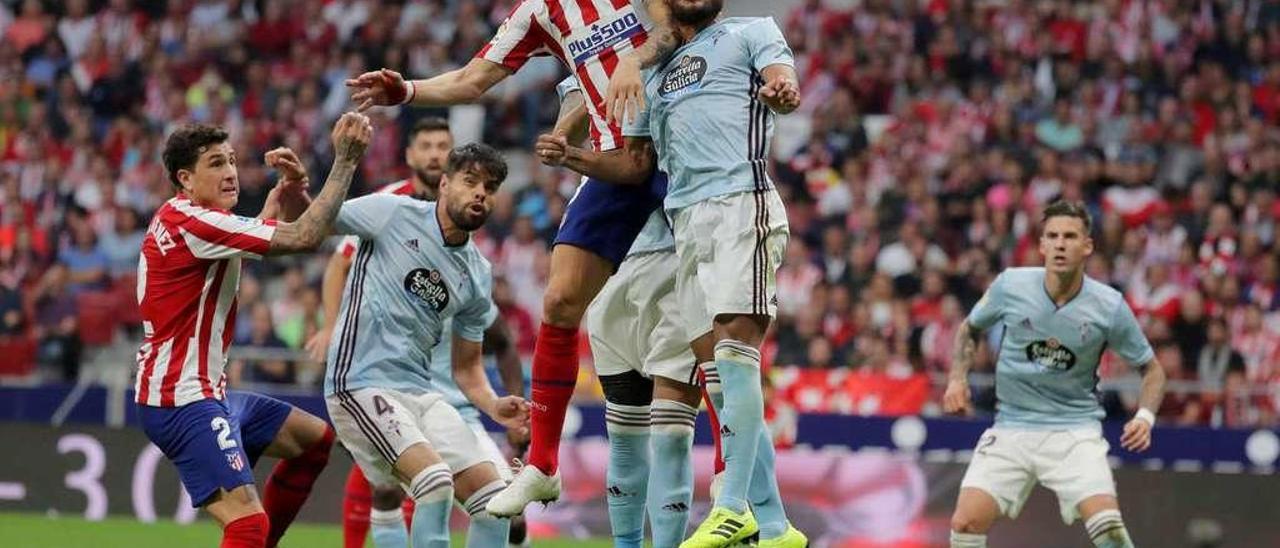 Denis golpea el balón antes dos adversarios el sábado en el Metropolitano. // Lof