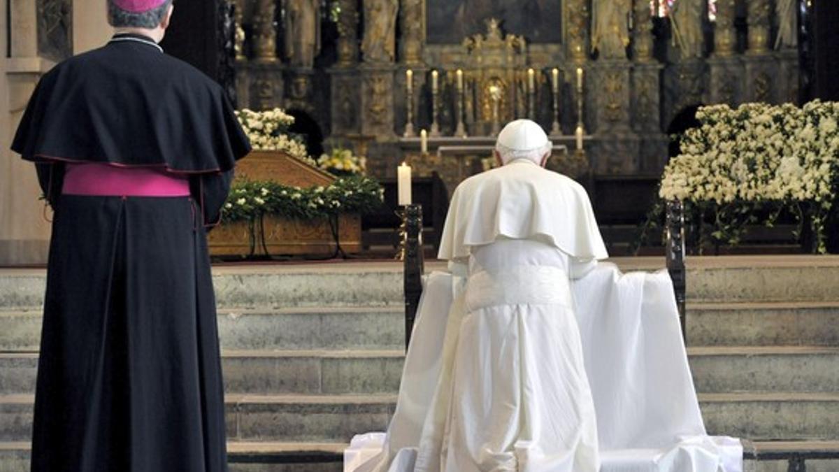 El Papa reza, arrodillado, ante el altar principal de la catedral de Erfurt, este viernes, en presencia del obispo Joachim Wanke.