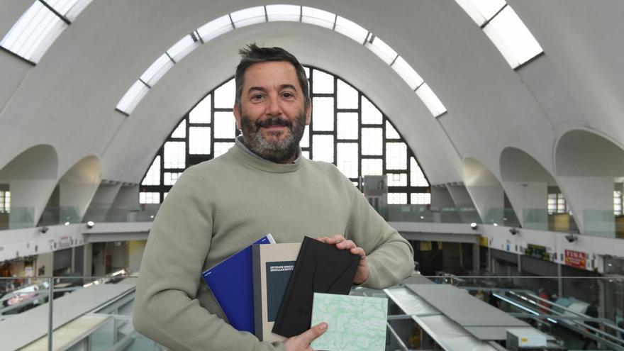 Juan Varela, con los proyectos editoriales del festival, en el mercado de San Agustín. |  Carlos Pardellas