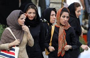 Iranian women walk in a street in Tehran 23 April 2007  The police bus screeches to a halt at a Tehran square packed with traffic  The officers leap out and begin spot checks on passing pedestrians and cars  Police work apparently like any other place in the world  But here in the Iranian capital their targets are women deemed to have infringed the Islamic republic s strict dress rules  AFP PHOTO ATTA KENARE