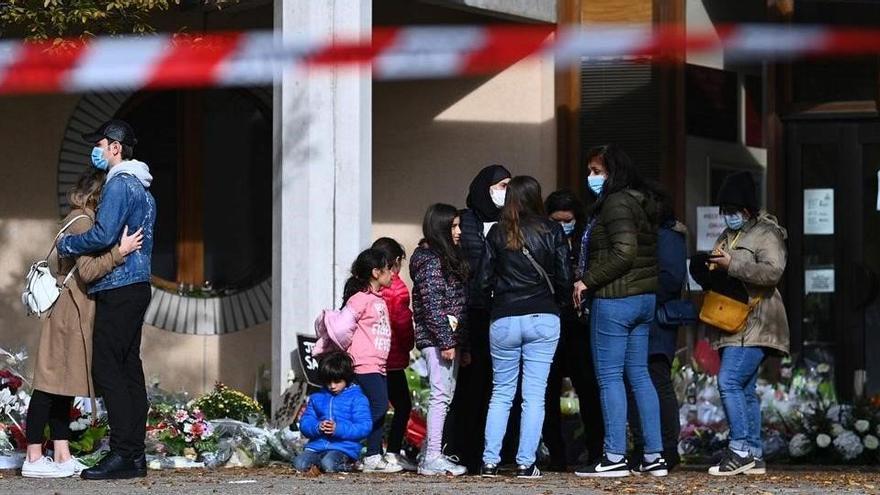 La gente coloca flores en los alrededores del centro en homenaje al profesor.