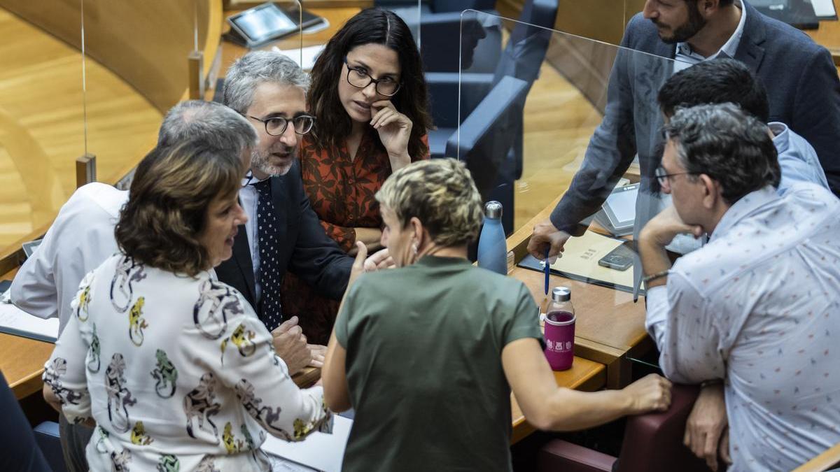 Aitana Mas y Arcadi España conversan con diputados del PSPV-PSOE y de Compromís.