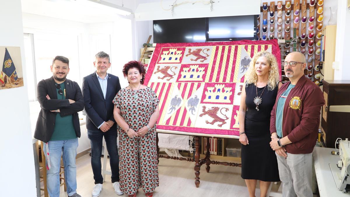 La familia Torres del Alcázar, la bordadora Silvia Teruel y Enrique Pérez, canciller de la Federación de San Clemente junto a la pieza.