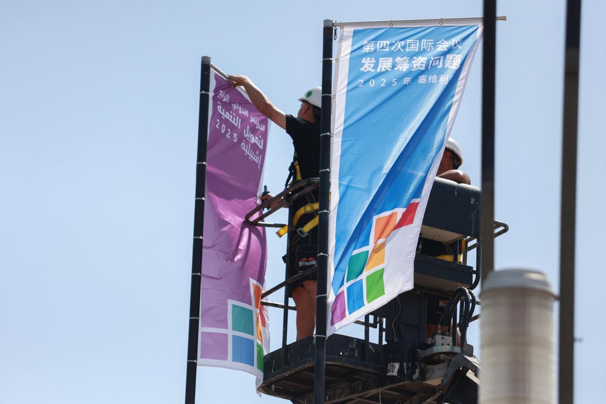 Operarios colocan banderolas en FIBES, en los días previos a la IV Conferencia Internacional de Naciones Unidas sobre la Financiación para el Desarrollo.