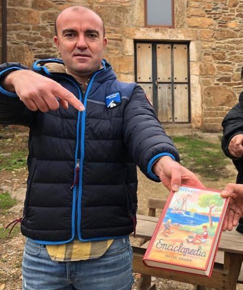 El alcalde pedáneo de Fonfría sostiene un ejemplar de la Enciclopedia Álvarez.