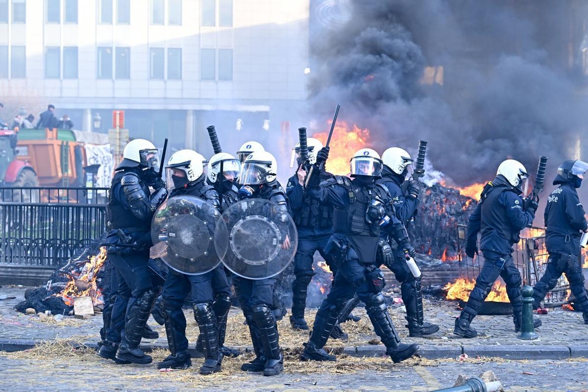 Agentes de policía con equipo antidisturbios vigilan la protesta agraria contra el acuerdo comercial con Mercosur.