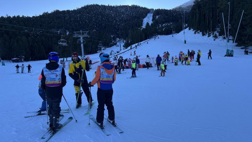 Un grup d'esquiadors amb un formador a l'estació de Masella (Cerdanya) i diversos esquiadors al fons