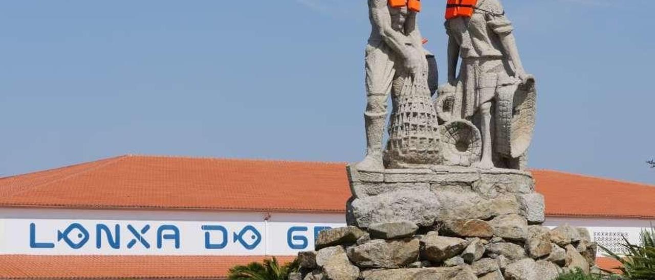 El monumento a la &quot;Familia Mariscadora&quot;, con los chalecos puestos. // Muñiz