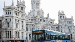 Autobús urbano de Madrid a su paso por delante de la sede principal del Ayuntamiento, el Palacio de las Telecomunicaciones.