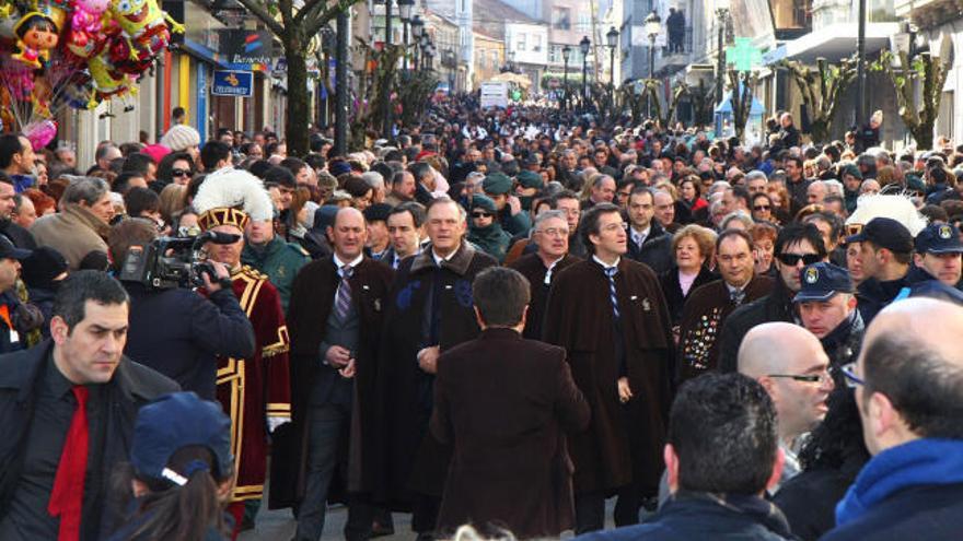 La comitiva desciende por la calle Principal, abarrotada de público, antes del pregón.  // Bernabé/Gutier