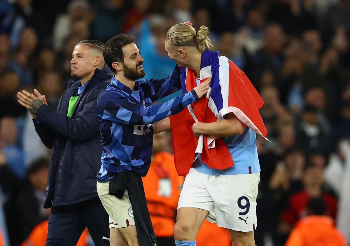 Bernardo Silva, jugador del Manchester City, le pone una bandera de Noruega al delantero Erling Haaland.