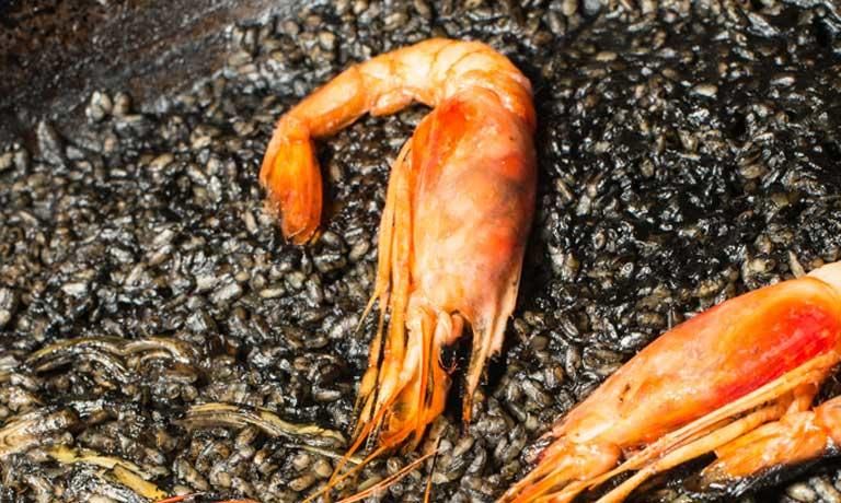 Arroz bomba negro con gamba roja pelada, ajos tiernos y alcachofa que cocinará AMPAR (Hospes Palau de la Mar).