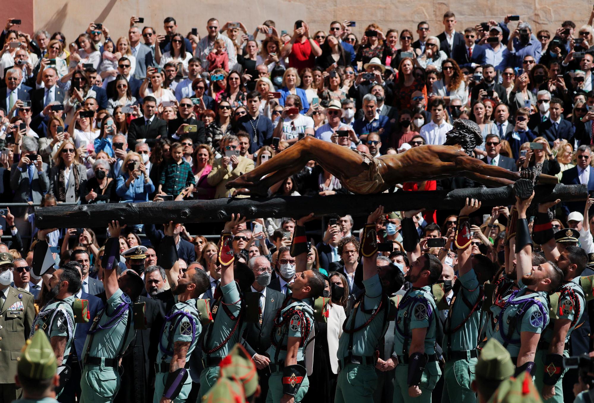 Legionarios del Tercio Gran Capitán, con sede en Melilla, alzan la figura del Cristo de la Buena Muerte y Ánimas este Jueves Santo en Málaga.