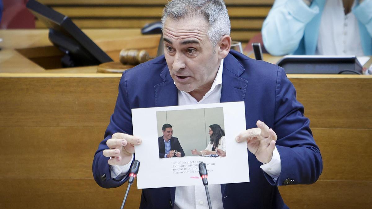 El síndic del PP, Miguel Barrachina, enseña una fotografía sobre Pedro Sánchez en las Corts.