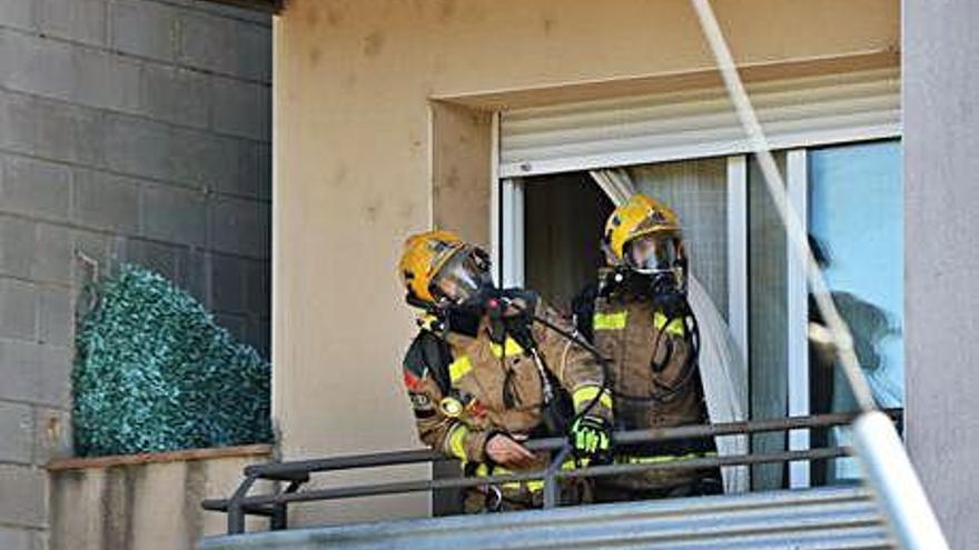 Bombers treballant en el balcó de l&#039;edifici afectat.