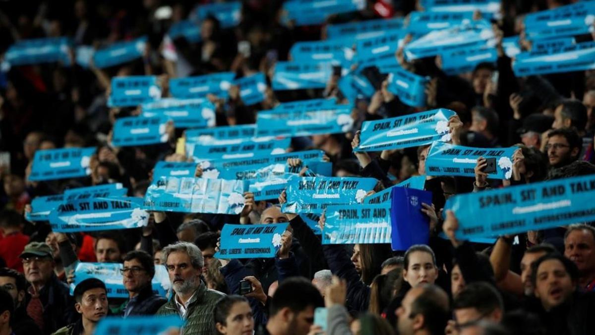 Carteles con el lema 'Spain sit and talk&quot; en el Camp Nou este miércoles, durante el clásico.