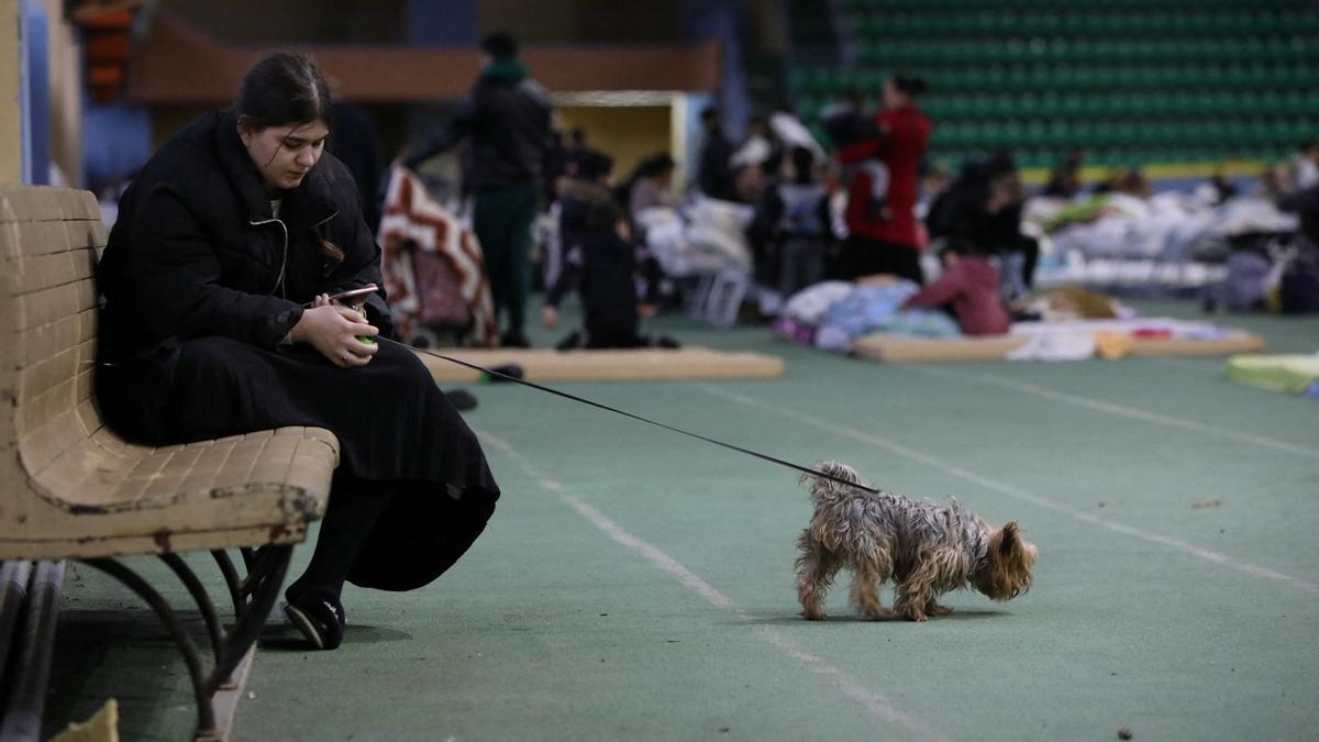 Una mujer con un perro en un centro de refugiados temporal para personas que huyen de la invasión rusa de Ucrania en un estadio local de atletismo en Chisinau, Moldavia, 4 de marzo de 2022