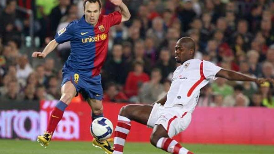 Andrés Iniesta regatea al sevillista Romaric en el duelo disputado el miércoles en el Camp Nou