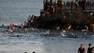 Personas migrantes caminan por la playa del Tarajal, en Ceuta, el pasado 17 de mayo de 2021. 