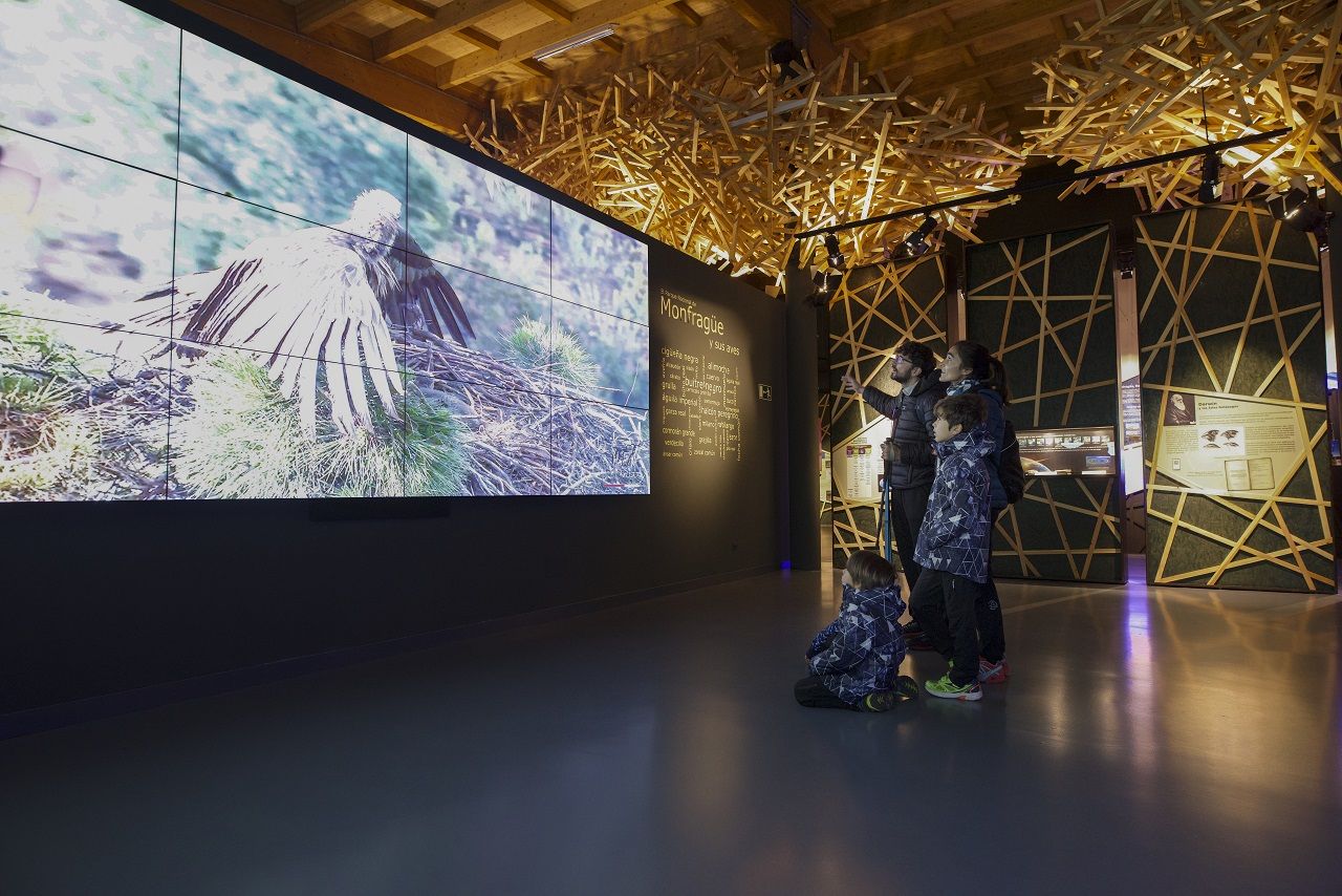 Una familia observa el interior del Centro de Visitantes Norte de Malpartida de Plasencia.