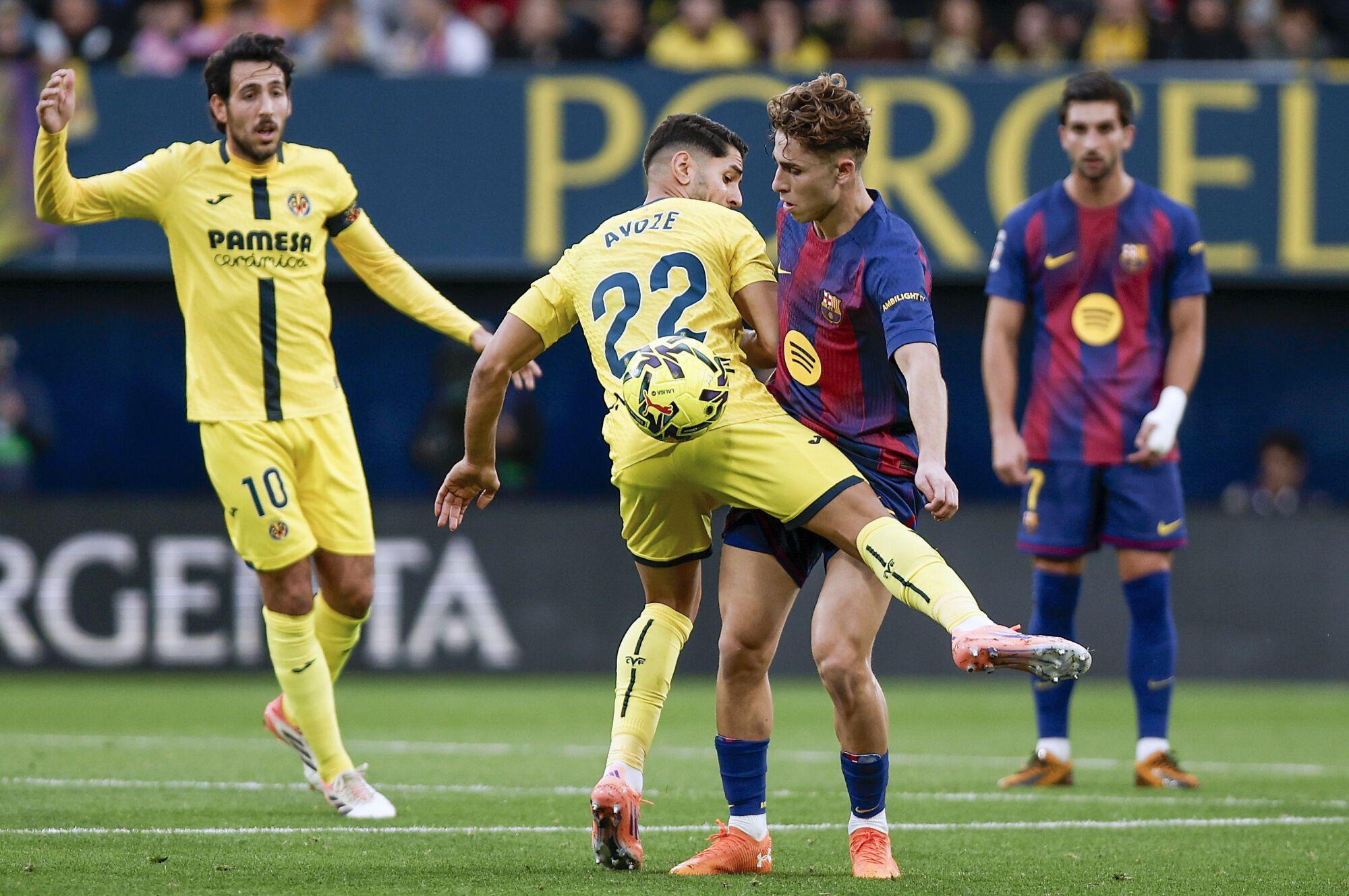 VILLARREAL (CASTELLÓN), 21/12/2025.- El delantero del Villarreal Ayoze Pérez (i) pelea un balón ante el centrocampista del Barça Fermín López este domingo, durante el partido de la jornada 17 de LaLiga EA Sports, que disputan Villarreal CF y el FC Barcelona en el Estadio de la Cerámica. EFE/ Biel Alino
