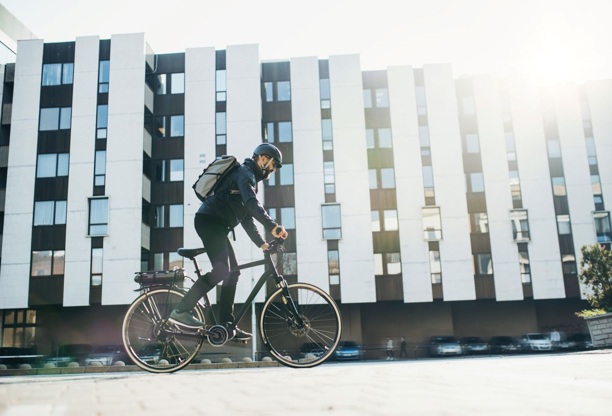 Hombre monta en su bicicleta eléctrica por la ciudad.