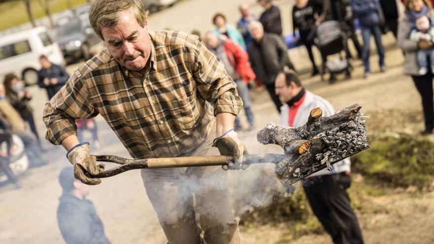 Els voluntaris vetllen perquè la pila de la carbonera es mantingui encesa.