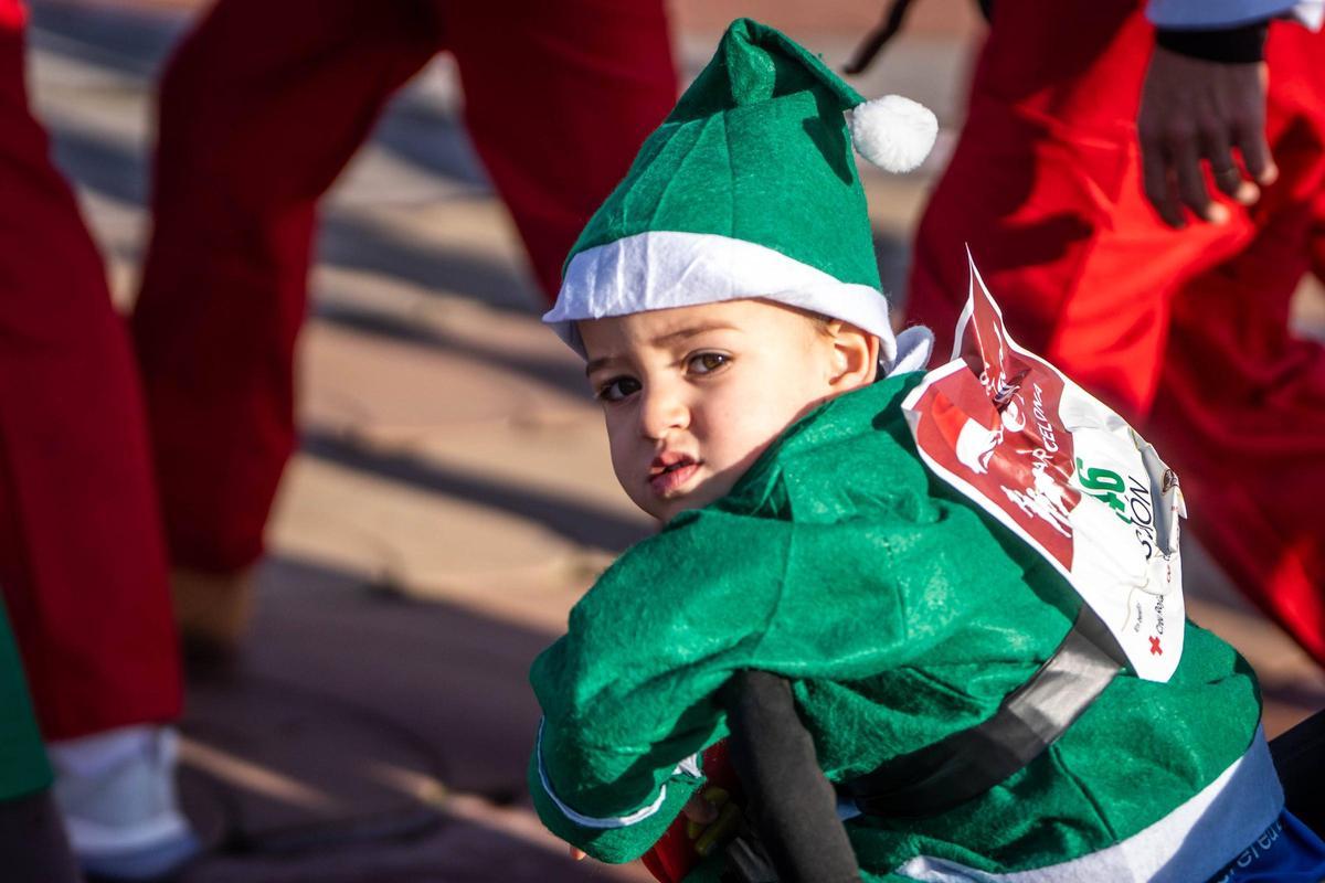 Un niño pequeño con un traje verde de elfo.