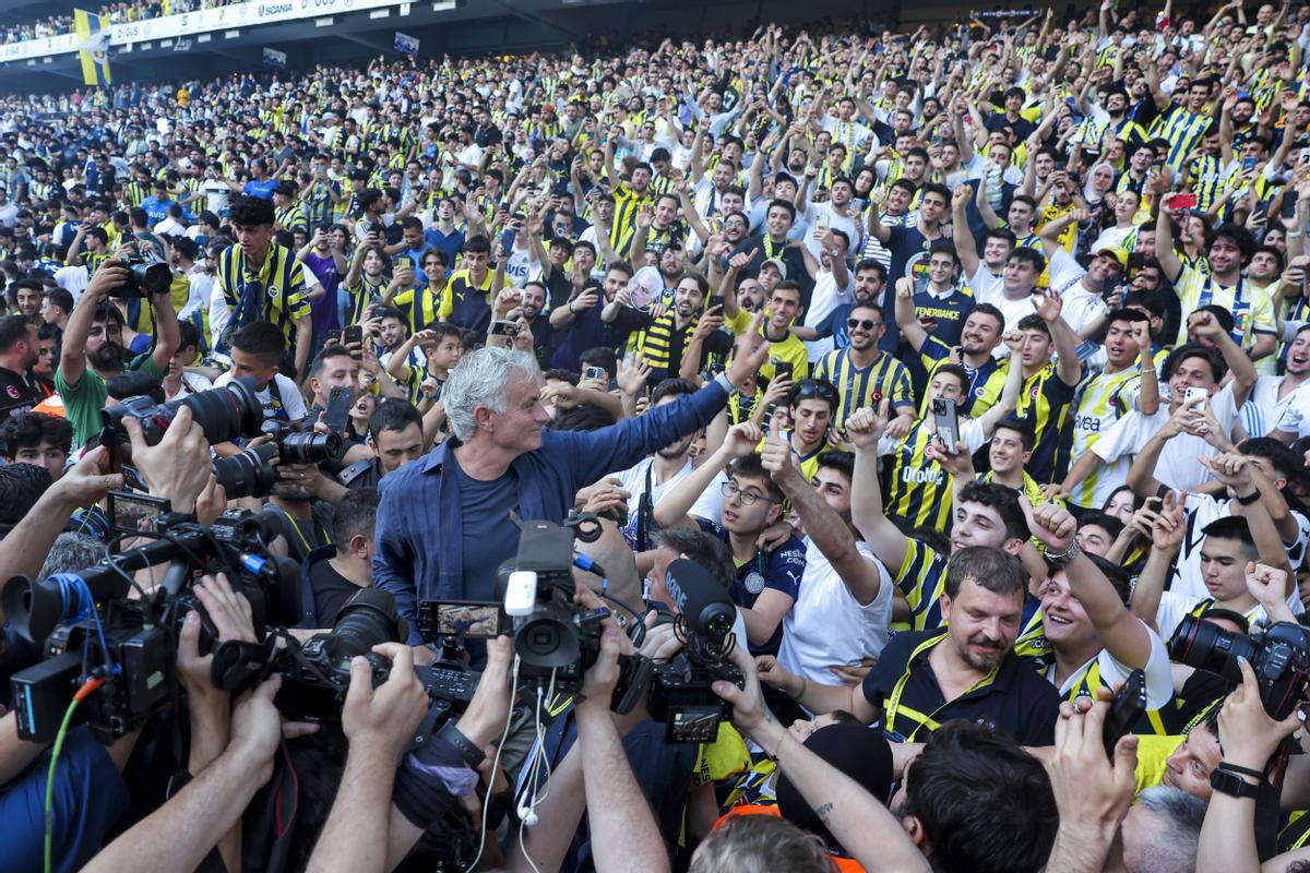 El entrenador de fútbol portugués José Mourinho, en el centro, saluda a los aficionados durante su presentación oficial como nuevo entrenador del Fenerbahce turco en el estadio Sukru Saracoglu de Estambul, Turquía, el domingo 2 de junio de 2024. Mourinho ha firmado un contrato de dos años con el Fenerbahce.