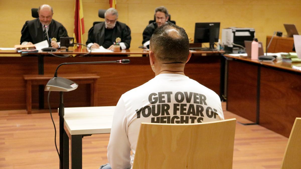 D'esquenes, l'acusat de violar una noia de 16 anys a Sant Feliu de Guíxols. Foto del judici a l'Audiència de Girona